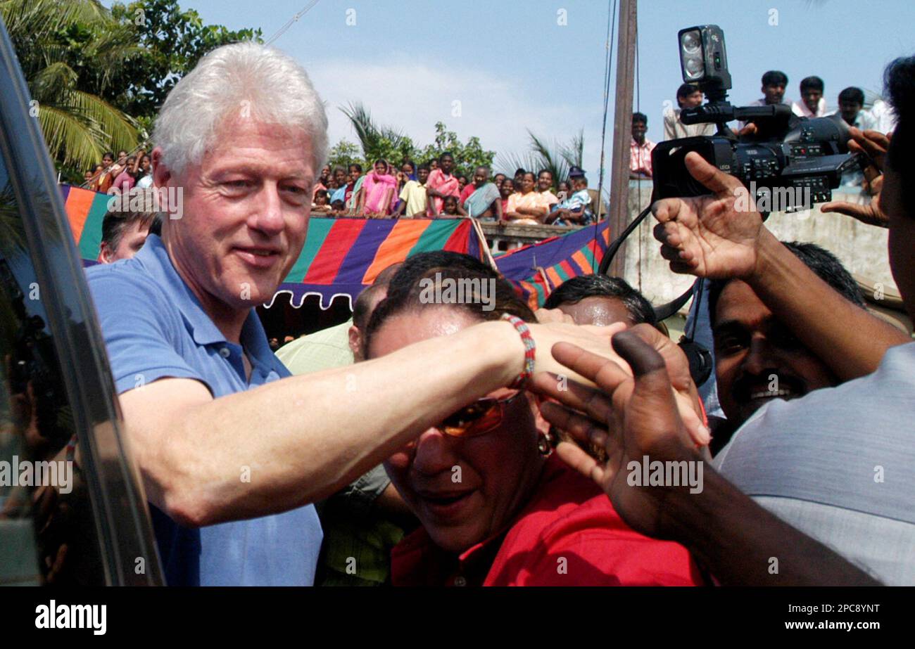 Former U.S. President Bill Clinton, left, interacts with local people while  visiting a tsunami affected area in Thazanguda, Cuddalore district, around  165 kilometers (103 miles) south of Chennai, India, Friday, Dec. 1,, image size:1300x923