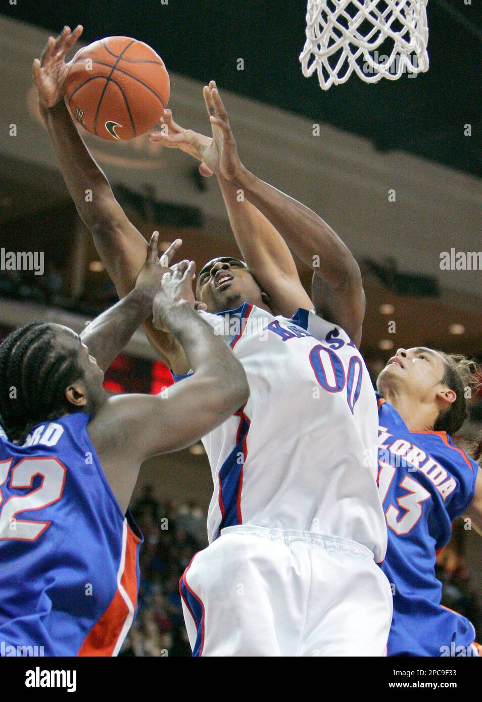 Kansas' Darrell Arthur is fouled by Florida's Joakim Noah, right, as