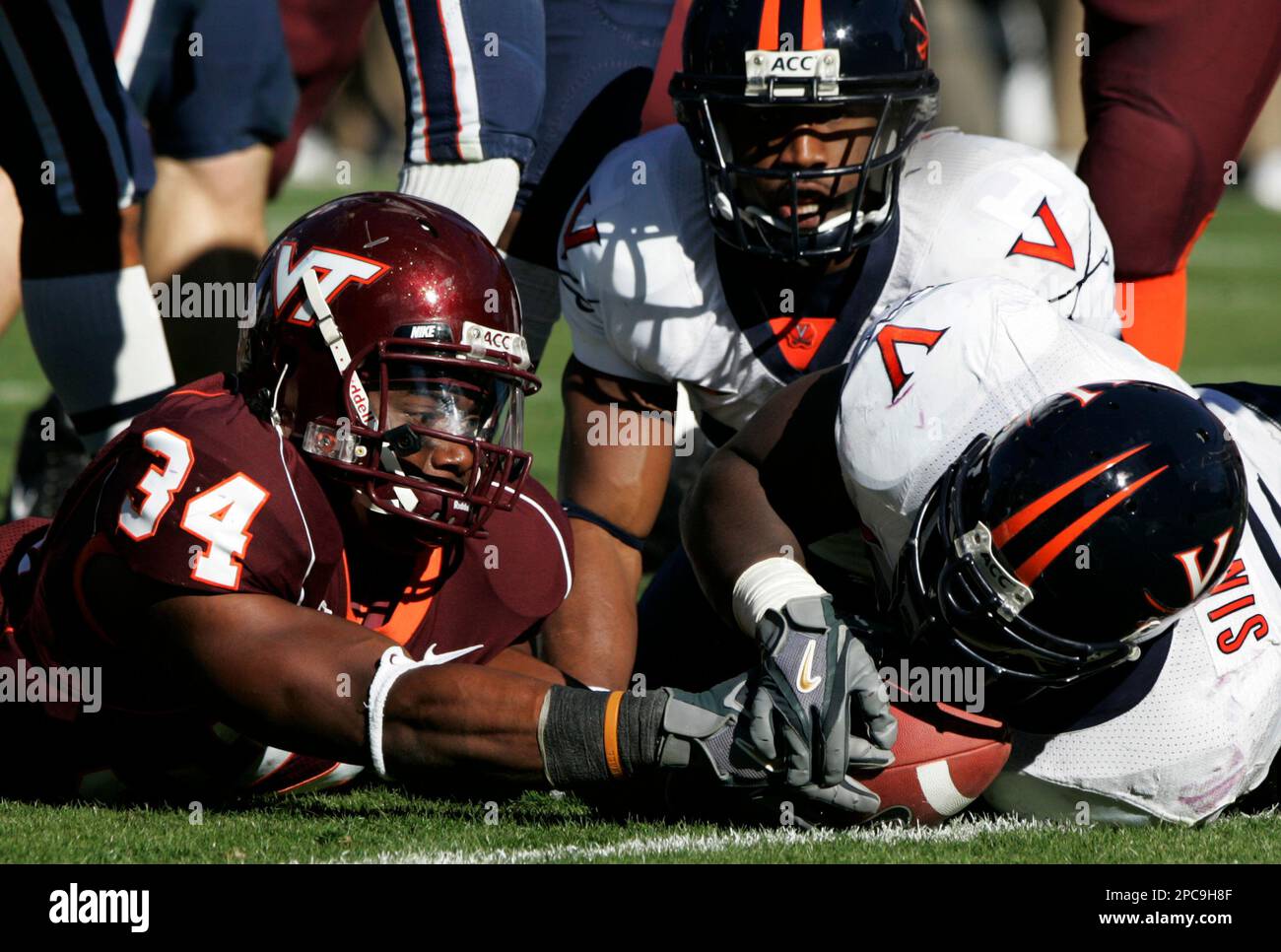 Virginia Tech running back George Bell (34) tries to stretch the ball  across the goal line as Virginia linebacker Clint Sintim (51) grabs the  ball during the Virginia-Virginia Tech college football game