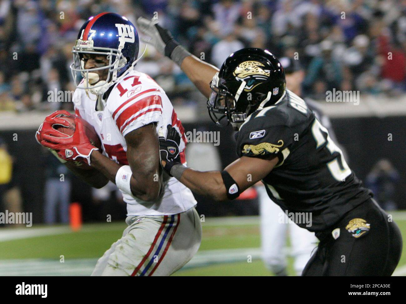 New York Giants receiver Plaxico Burress, left, scores a third