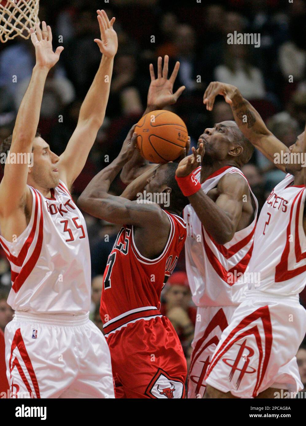Chicago Bulls' Ben Gordon (7), of England, tries to shoot as Houston  Rockets' Scott Padgett (35), Dikembe Mutombo (55) and Luther Head, right,  defend during the first quarter of their NBA basketball