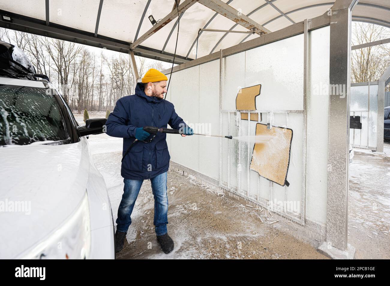 Man washing high pressure water car carpets at self service wash in cold weather Stock Photo Alamy