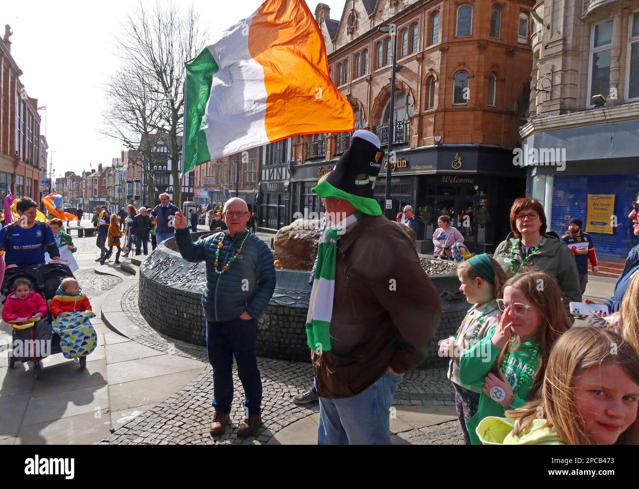 St Patricks Day 2023 Irish Community parade Orford Ln Warrington to Bridge Street IRA bombing memorial, Cheshire, UK - Man with Tricolour Stock Photo