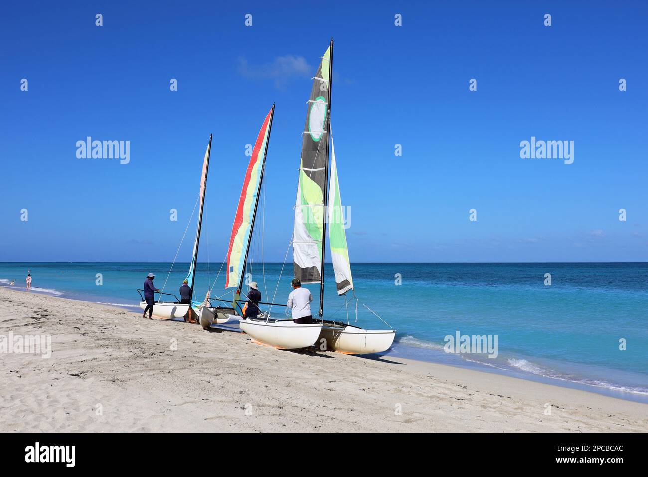 Sailing catamarans on a sand on blue ocean background. Water sports on