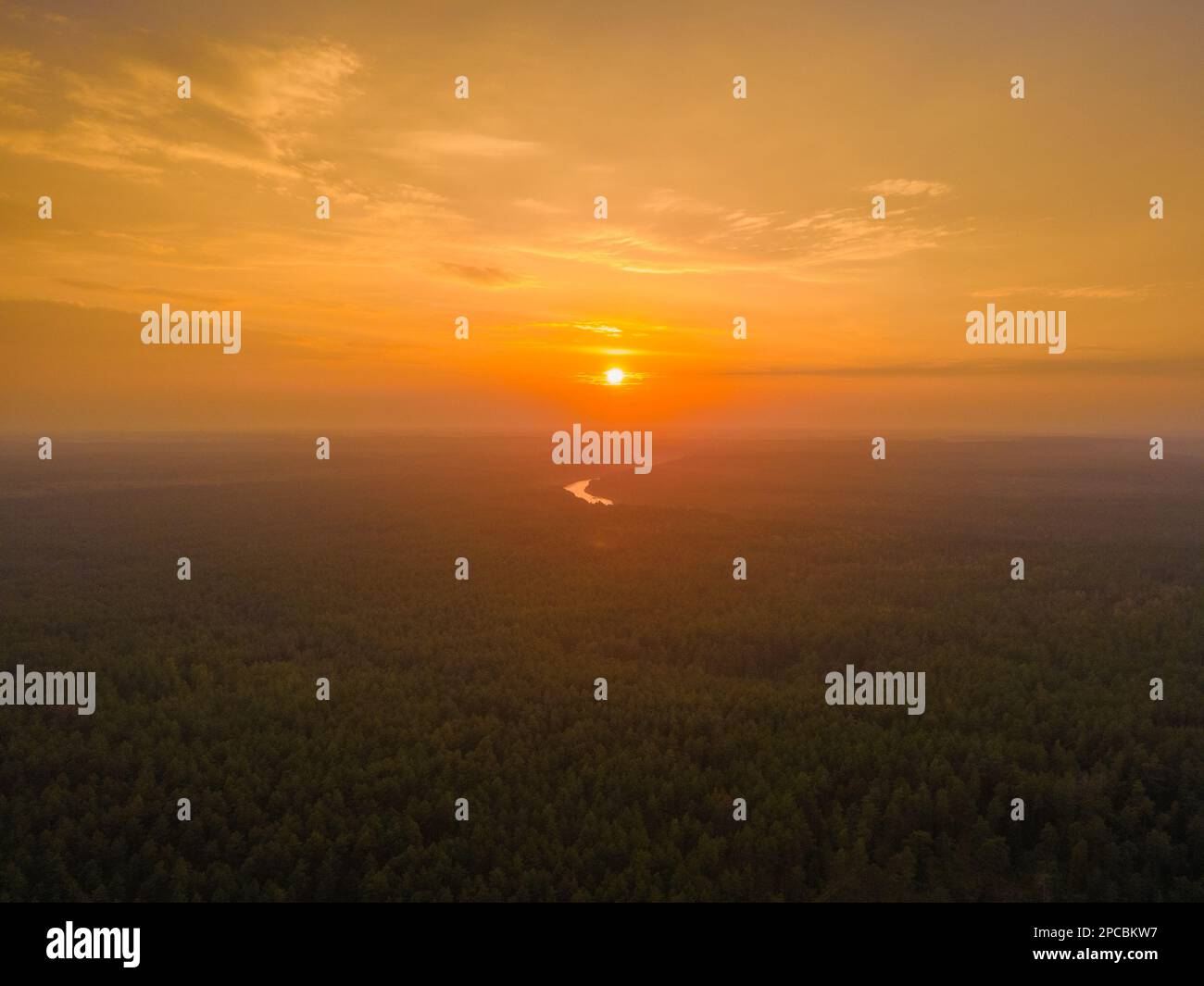 Aerial view of an orange sunset in the horizon over the forest Stock ...