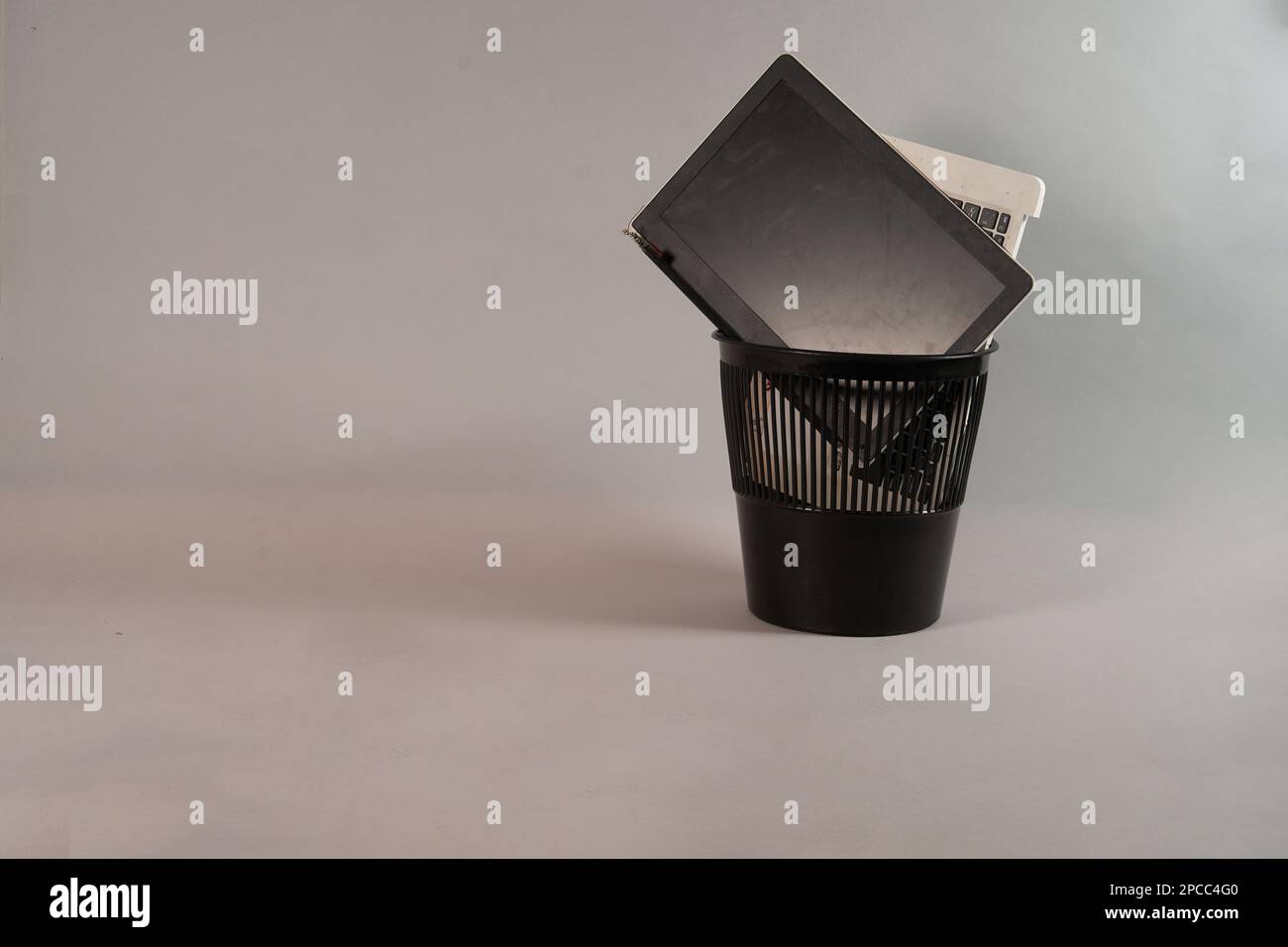 Electronic waste, broken or damaged, laptop in the trash, on a gray