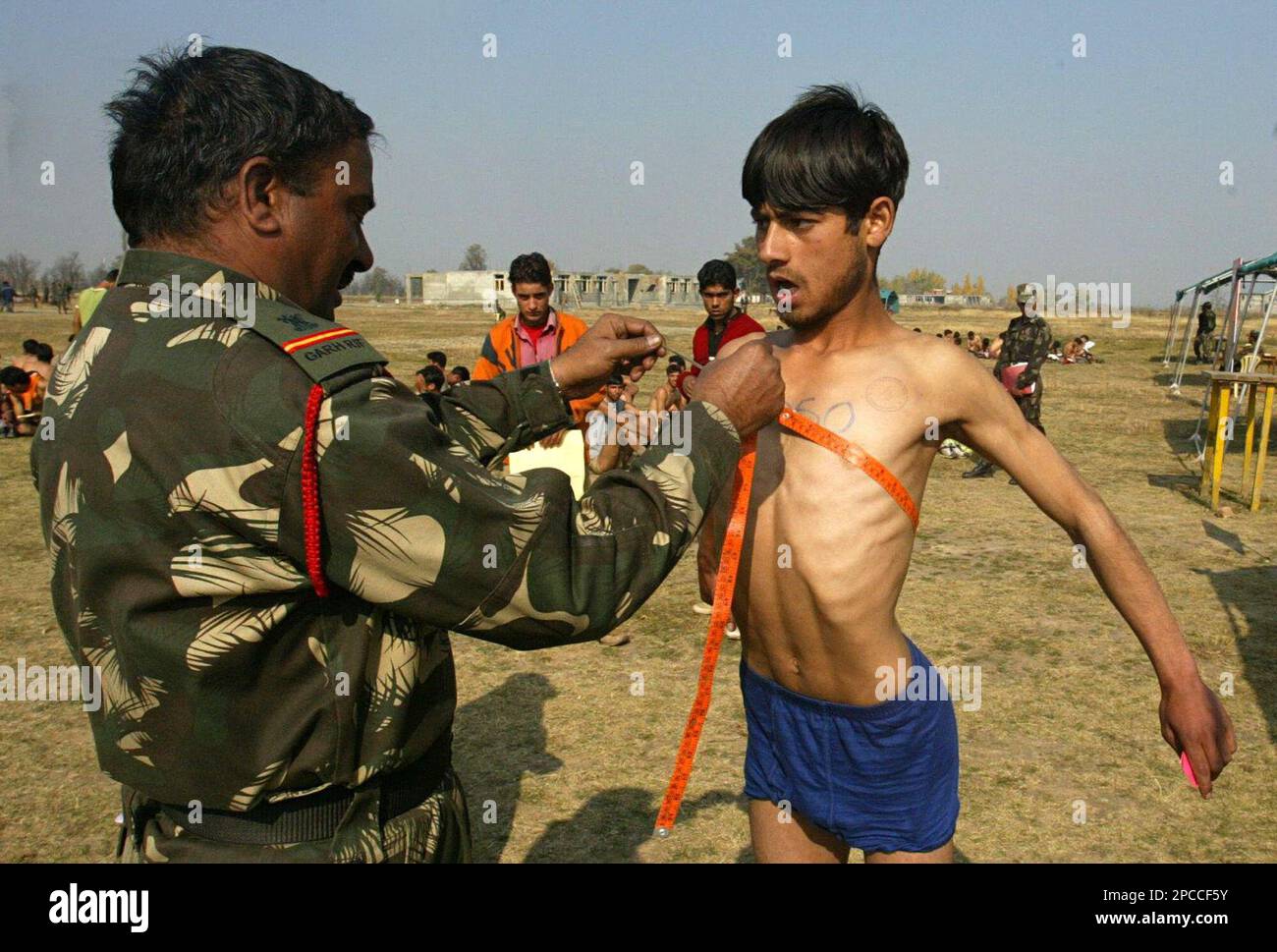 An Indian army officer measures the chest of a Kashmiri during an 