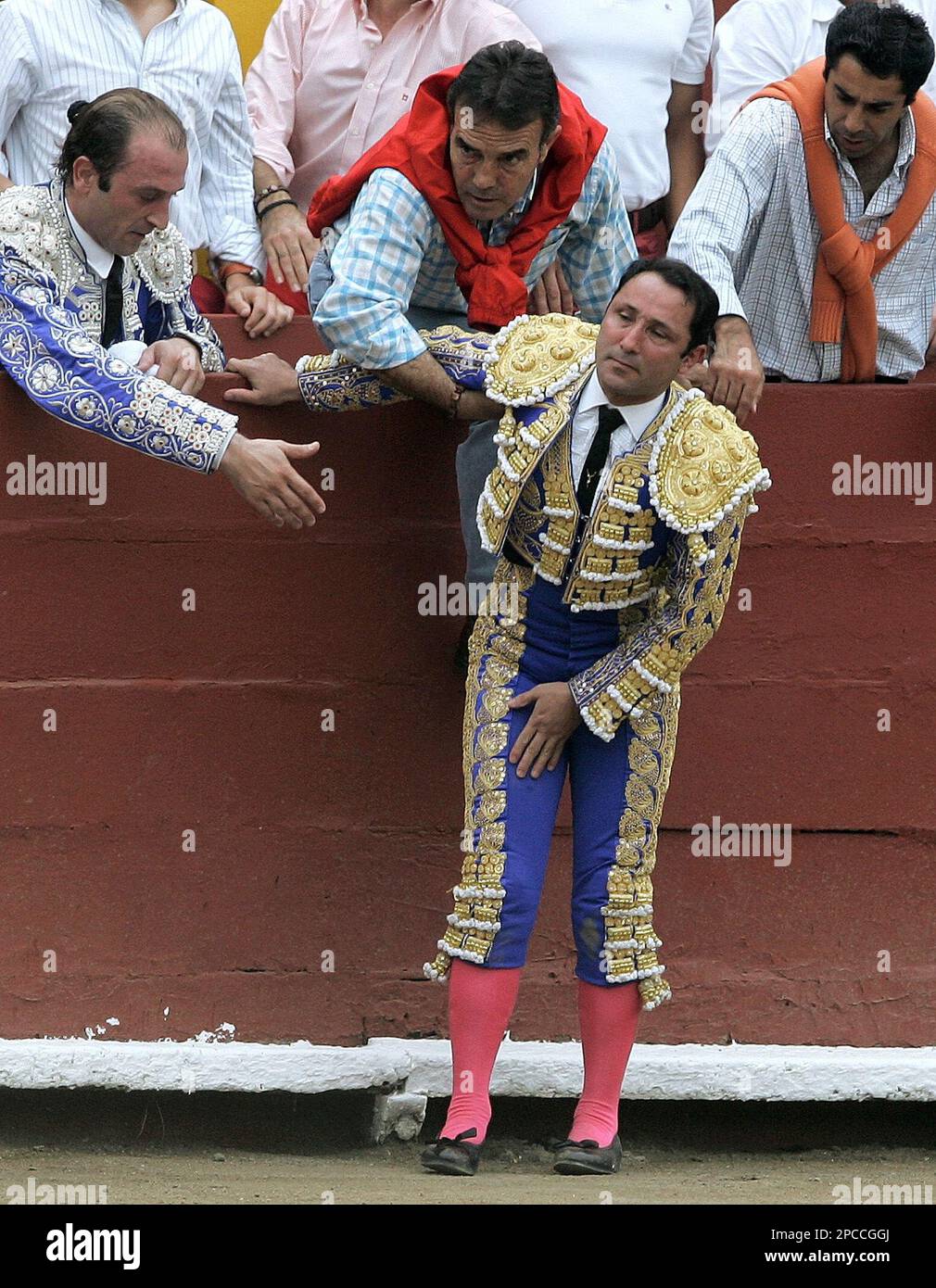 Colombian bullfighter Cesar Rincon is helped by unidentified men after ...