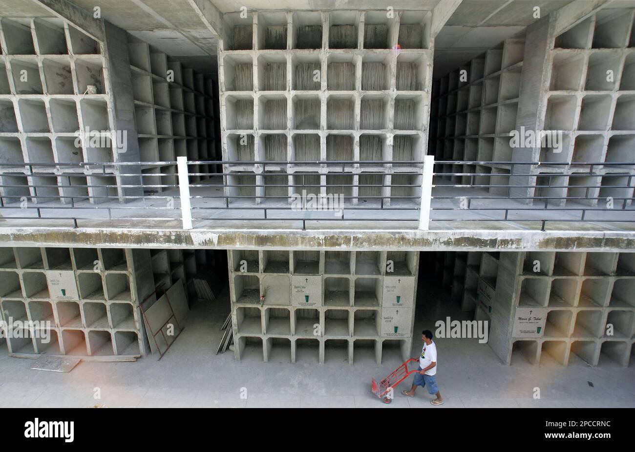 A Filipino worker passes by a new building that houses apartmenttype