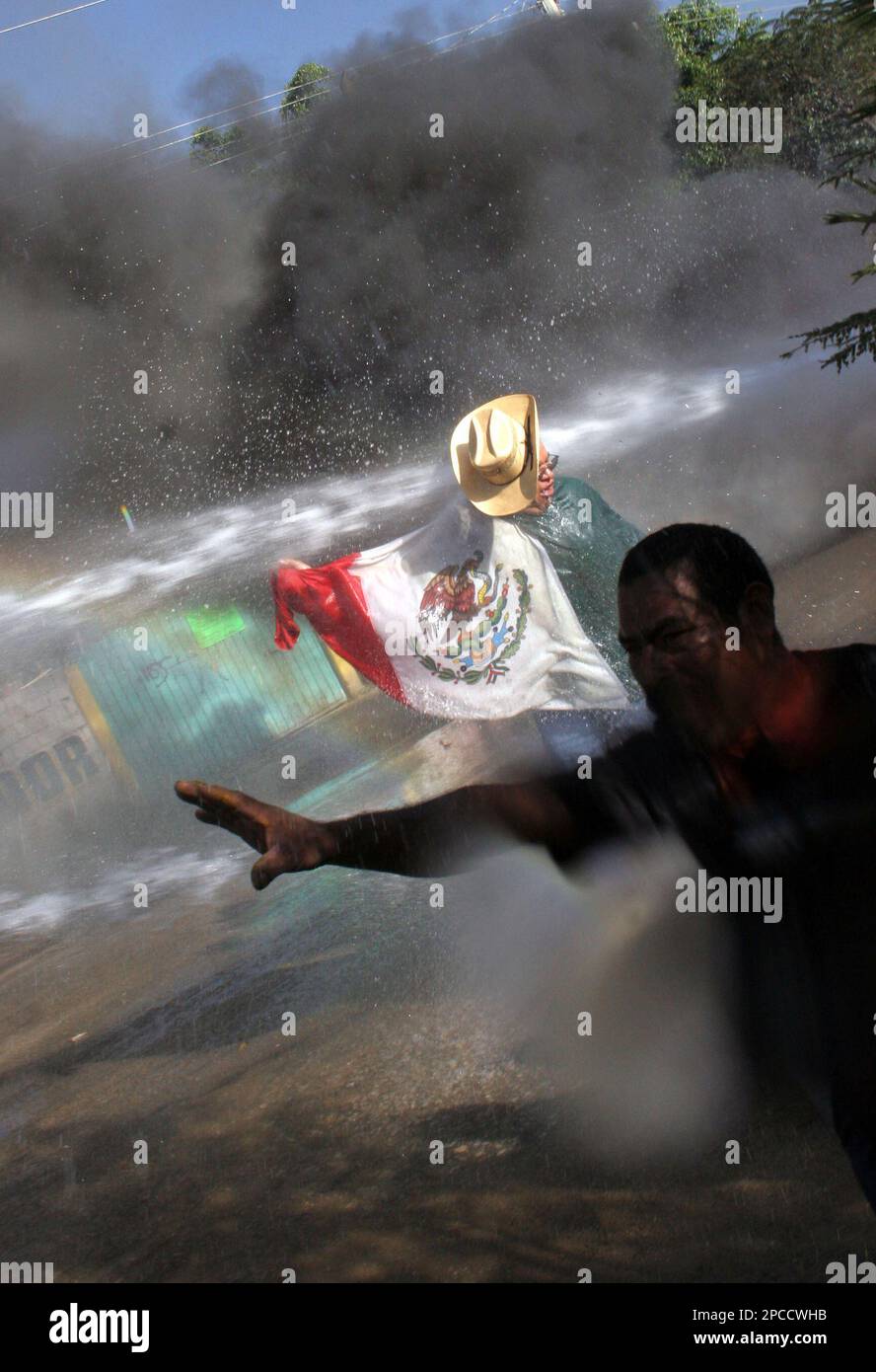 Protesters are hit by water canons as federal police advance in the city of  Oaxaca, Mexico on Sunday Oct. 29, 2006. Federal police with assault rifles  and riot-shields advanced into Oaxaca, pushing