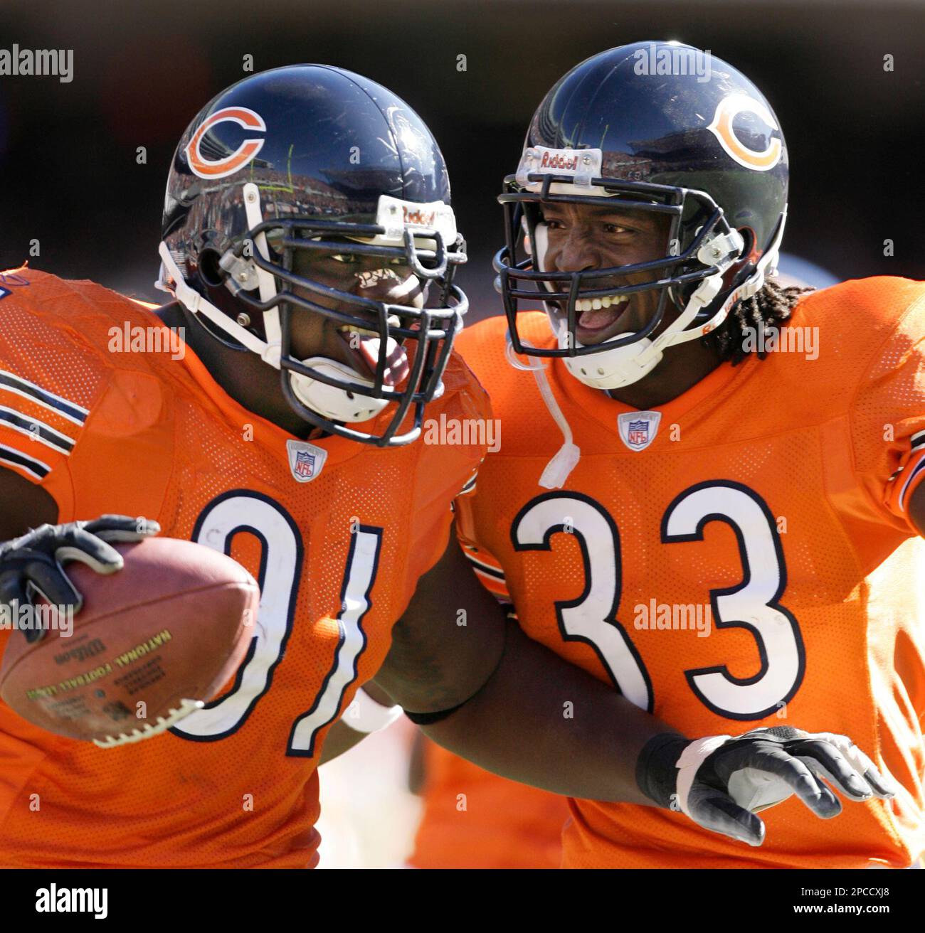 Chicago Bears defensive tackle Tommie Harris, left, sticks his