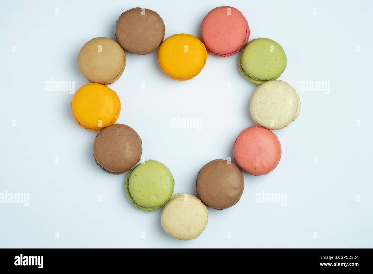 Multi-coloured Macarons on white background arranged in a heart Stock Photo