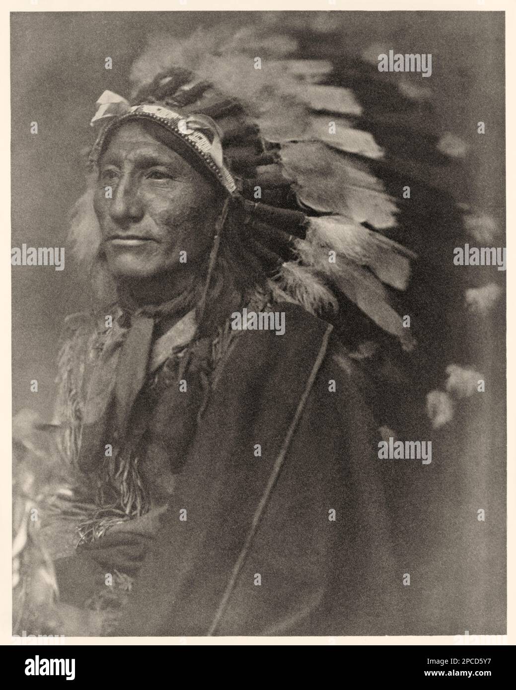 1902 ca , USA : Indian chief.  Portrait of Native American man in headdress and robe. Photo by woman photographer Gertrude Kasebier ( 1852 - 1934 ) , photomechanical print edited by Camera Club , New York, USA  - foto storiche - foto storica  -  Indians - INDIANI D' AMERICA - natives americans  - Indians of North America -  CAPO INDIANO - portrait - ritratto - pellerossa - piuma - copricapo di piume - feathers - foto pittorialista - pictorialist photograph - CAMERA WORK -    ----  Archivio GBB Stock Photo