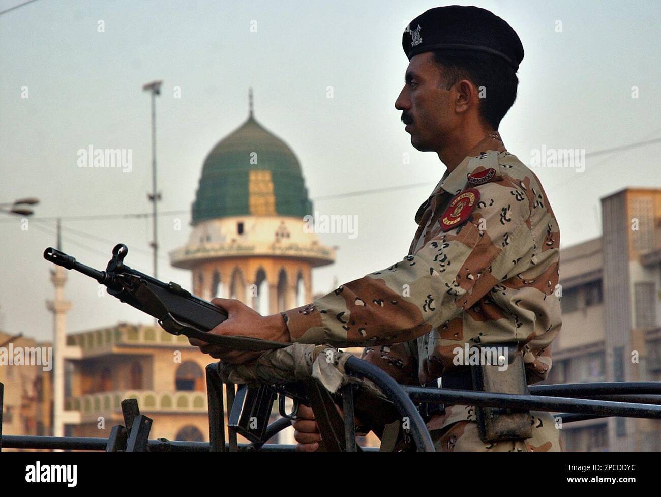 A Pakistani paramilitary soldier stands guard at a mosque, where