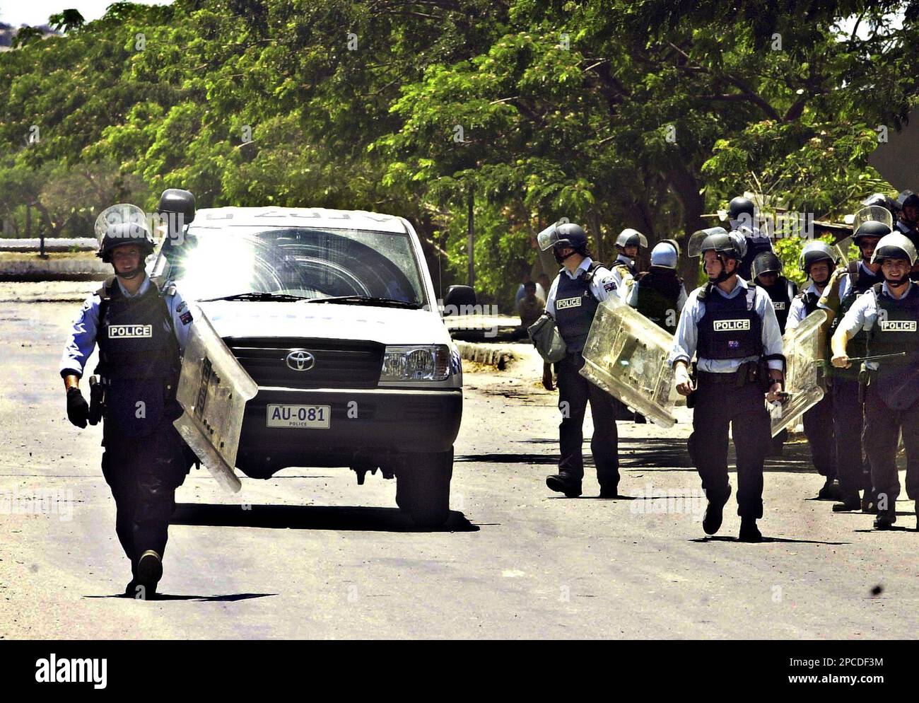 Australian police officers in riot gears patrol an area near the ...