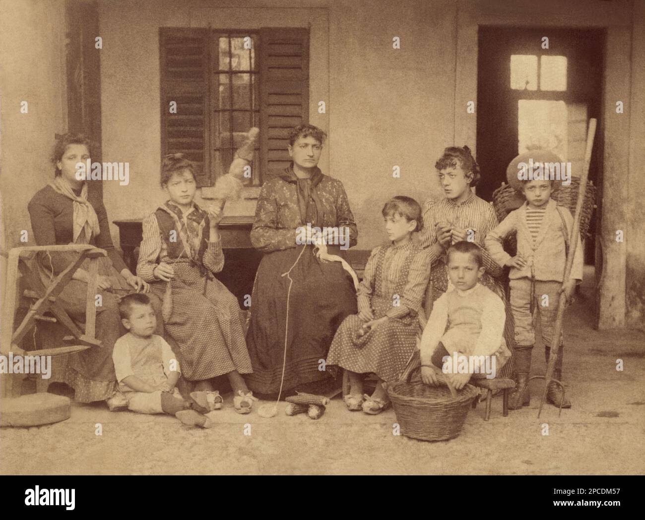 1895 ca, LOMBARDIA, ITALY   : Photograph of a rural family  on the door, takes in housework . Undentified photographer .-  FOTO STORICHE - HISTORY PHOTOS  -  child  - bambina - bambine - BAMBINO - BAMBINI -  cascina - fattoria - farm - CHILDREN - BABY - contadini - civiltà contadina - peasants -  sorella - fratello  - FRATELLI -  INFANZIA -  CHILDHOOD - OTTOCENTO - 800's - '800 - filatura della lana - LOMBARDY- GEOGRAPHY - GEOGRAFIA  - FAMILY - FAMIGLIA ----  Archivio GBB Stock Photo