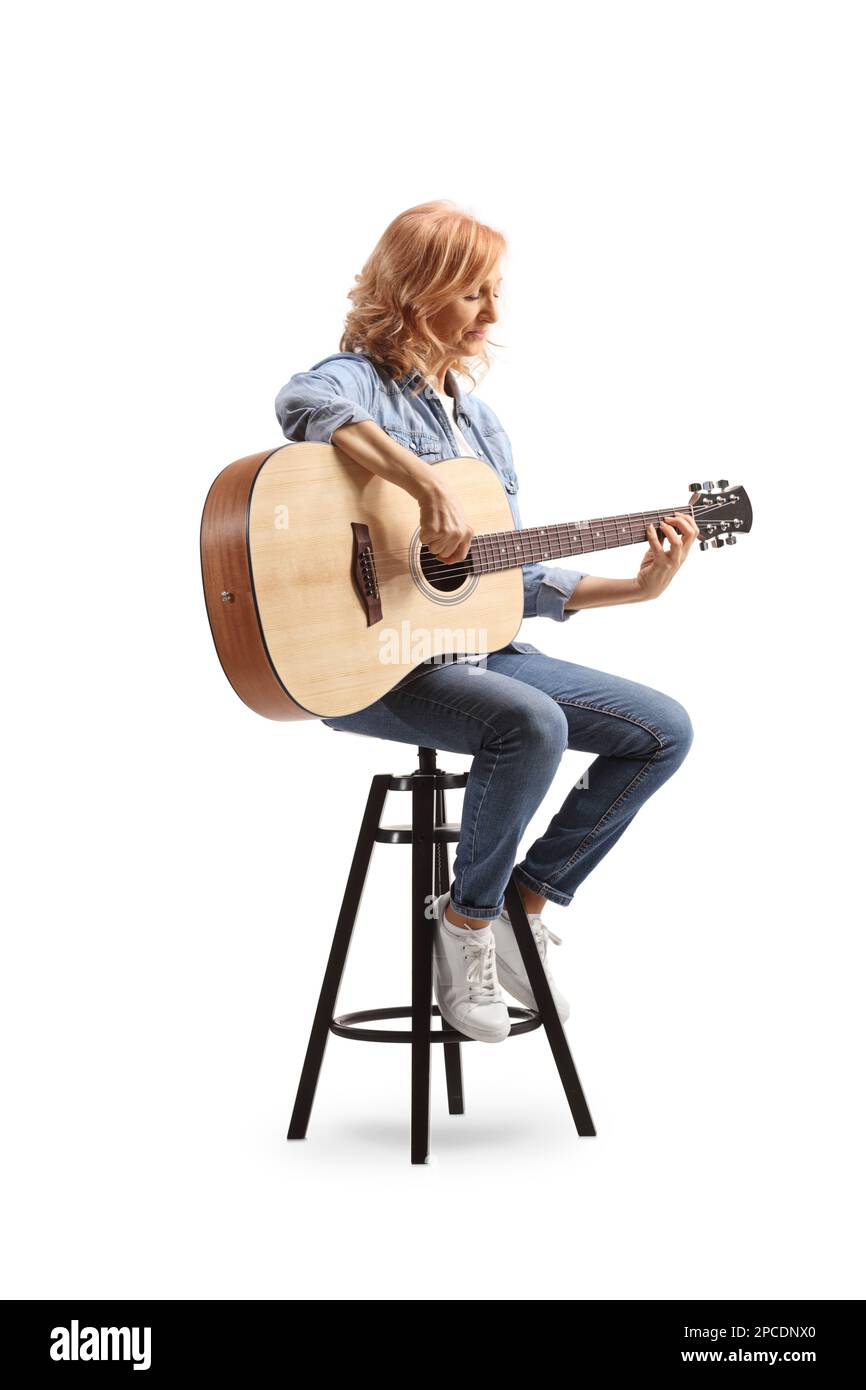 Woman sitting on a chair and playing an acoustic guitar isolated on