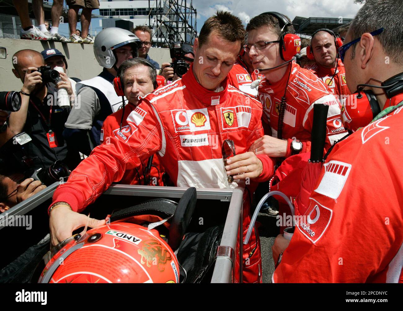 Germany's Michael Schumacher picks up his helmet before the start of