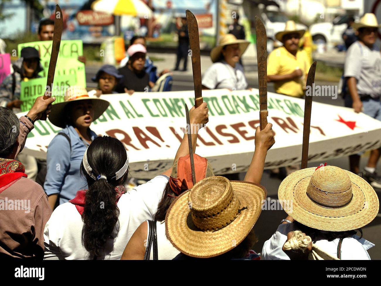 Farmers from San Salvador Atenco brandish their machetes to support