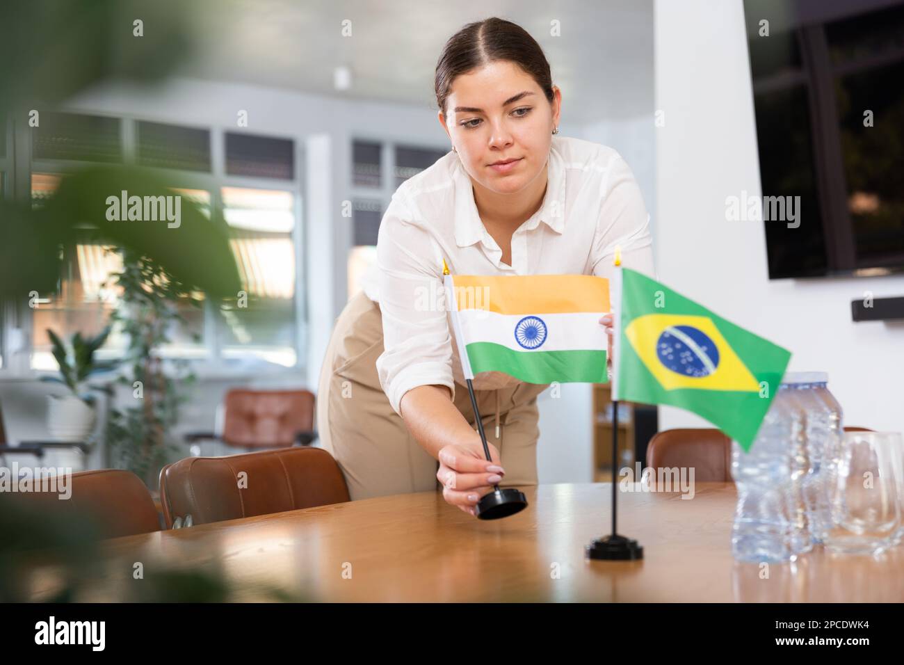 female assistant prepares conference room for diplomats of Brazil and ...