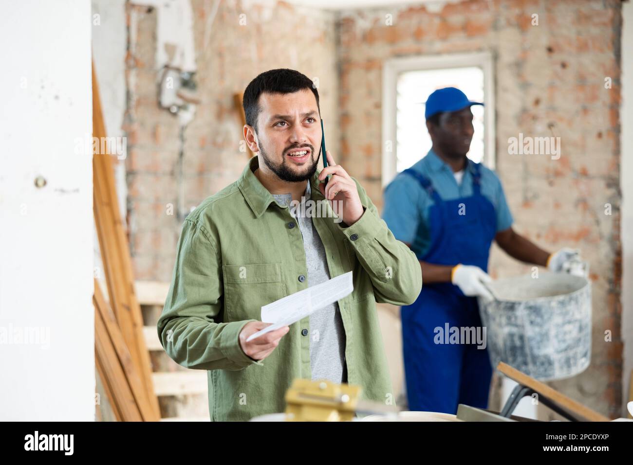 Man architect having telephone conversation about project documentation Stock Photo