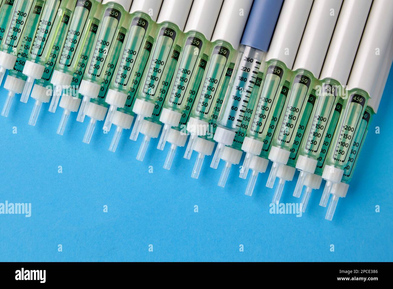 Diabetic insulin pens lined up on a blue background. Provision of