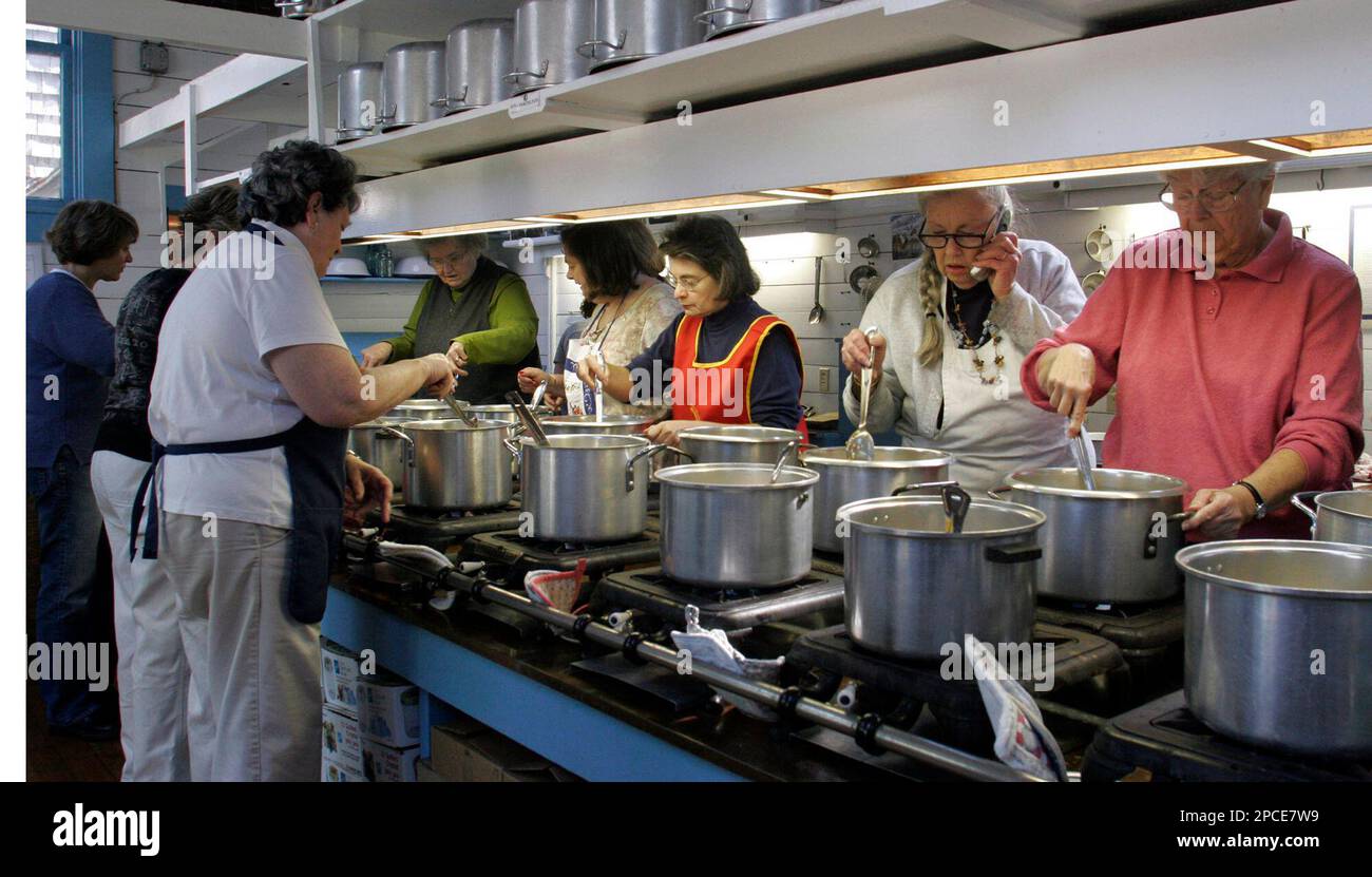 Betsy King of North Falmouth, Mass., second from right, chats on her cell phone while making