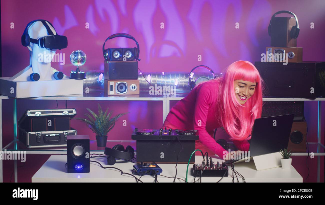 Smiling musician standing at dj turntables mixing sounds during