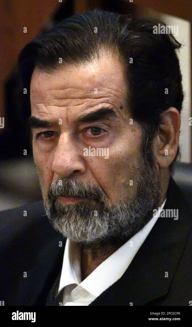Former Iraqi leader Saddam Hussein listens to prosecutors during his ...