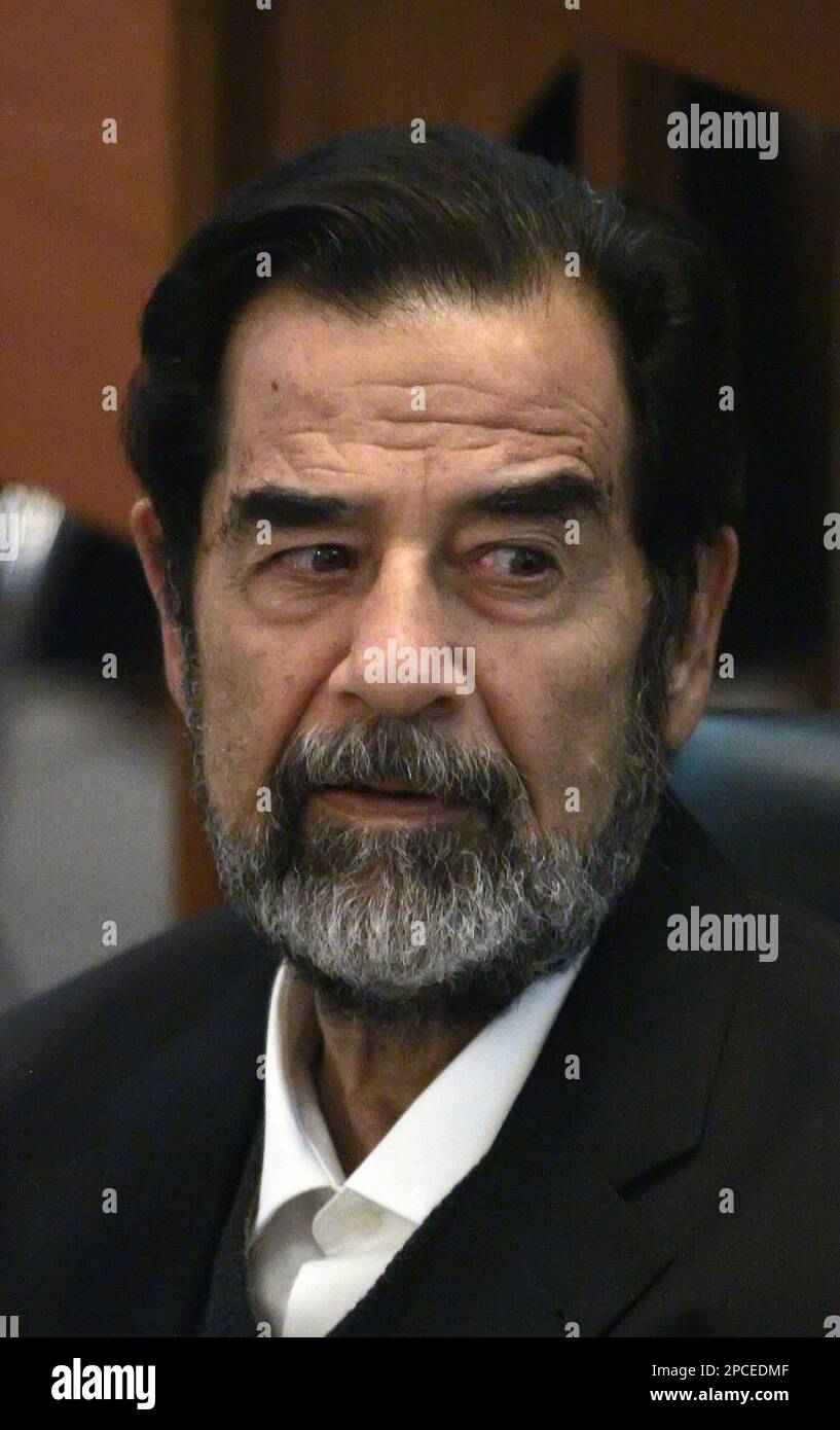 Former Iraqi leader Saddam Hussein listens to prosecutors during his ...