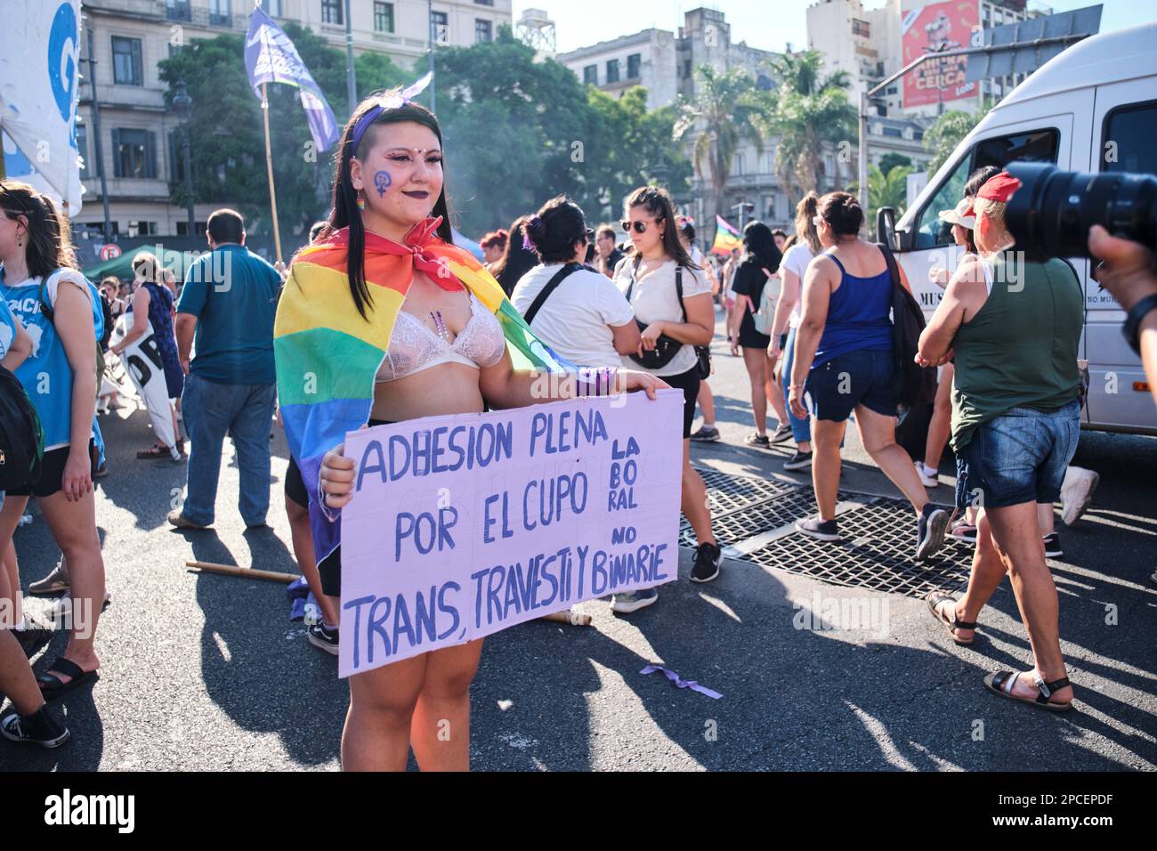 Buenos Aires, Argentina; March 8, 2023: International women day. Woman with a rainbow flag holds a sign: Full support for the trans labor quota Stock Photo