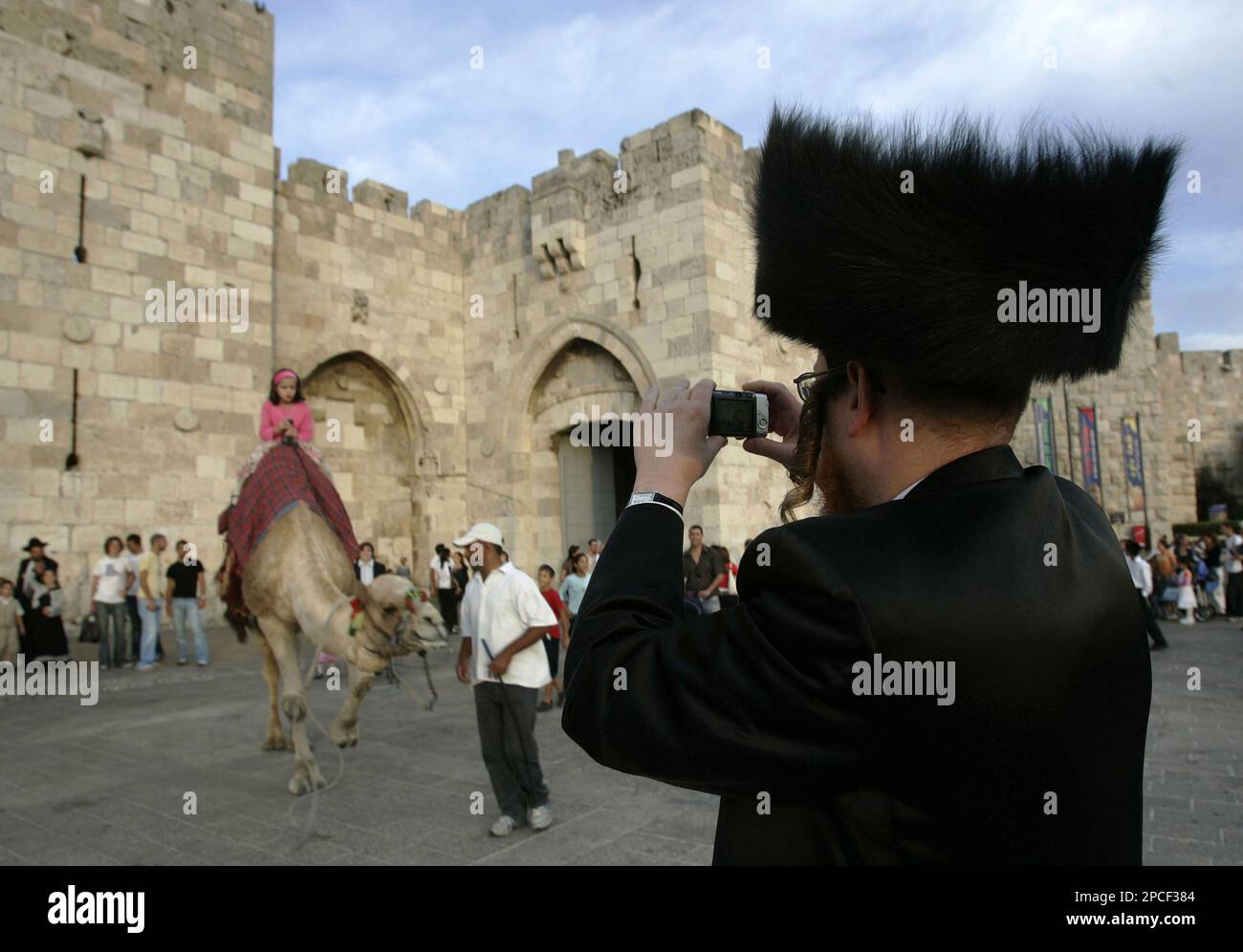 An Israeli Ultra-orthodox Jew takes a picture of his daughter riding a ...
