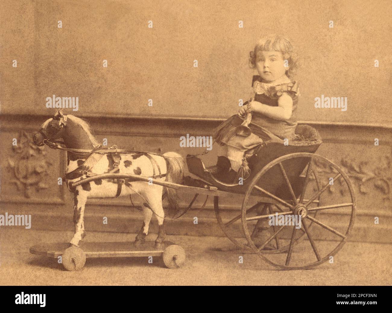 1875 ca, Dresden , GERMANY  : A child with  a little carriage toy horse . Photo by W. Hoffert , Dresden - TOYS - CAVALLINO - CAVALLO - HORSE - CALESSE - CALESSINO - CARROZZA - CARROZZINA - giocattolo - TOYS - GIOCO - giocattoli  - FOTO STORICHE - HISTORY PHOTOS -  cavalluccio di legno - wood -    - PRUSSIA - SASSONIA - SACHSEN - GERMANIA  - bebe' - BAMBINO - BAMBINI - CHILDREN - BAMBINA - BABY -  '800 - 800's - OTTOCENTO  - little boy - trumpet - trombetta - tromba - DRESDA - FASHION - MODA   -----  Archivio GBB Stock Photo