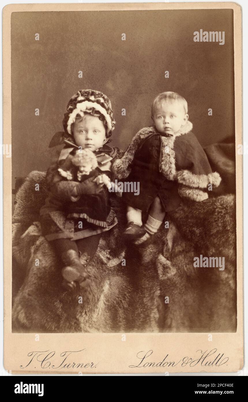1880 ca , London , GREAT BRITAIN : Two brothers with toys . Photo by T.C. Turner , London and Hull  - TOY - giocattolo - giocattoli  -  BAMBOLA - bambole - DOLL - DOLLS - FRATELLI - FOTO STORICHE - HISTORY PHOTOS  -    - child  - bambina  - BAMBINO - BAMBINI - CHILDREN - BABY - babies -  INFANZIA  - CHILDHOOD -   -OTTOCENTO - '800 - 800's - FASHION - MODA - cappello - hat - cuffia - fur - pelliccia - EPOCA VITTORIANA  - gioco - giochi -----  Archivio GBB Stock Photo