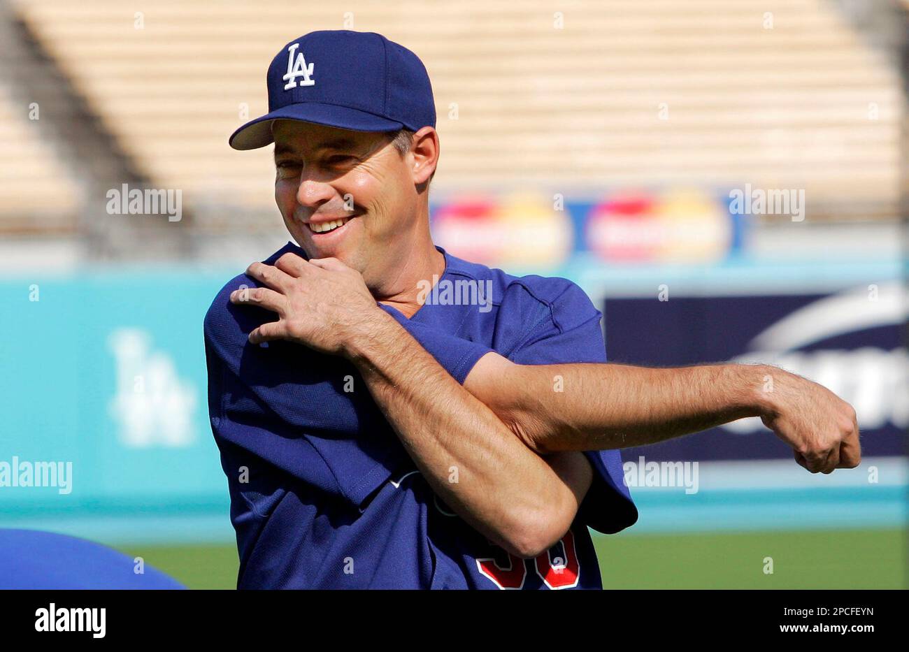 Los Angeles Dodgers pitcher Greg Maddux stretches in the dugout