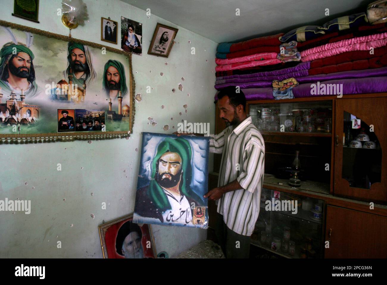 Ullet Riddled Wall A man replaces paintings of Imam Hussein on the bullet riddled wall ...