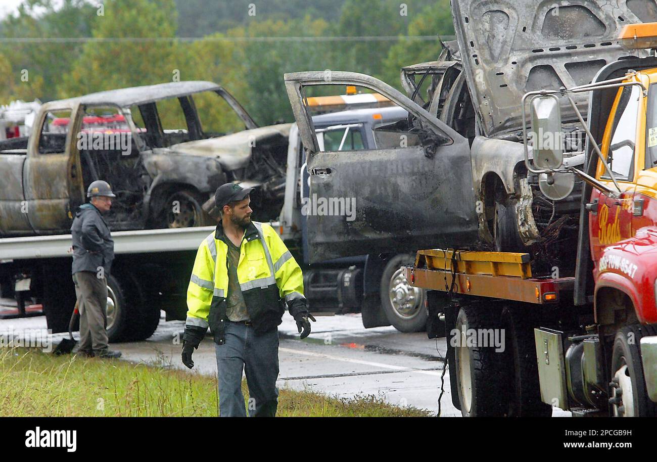 Wrecker crews prepare to haul away wreckage from a fiery crash that ...
