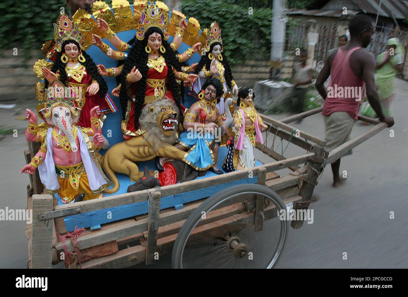 A Man Pulls A Cart With An Idol Of Hindu Goddess Durga Loaded In a-man-pulls-a-cart-with-an-idol-of-hindu-goddess-durga-loaded-in