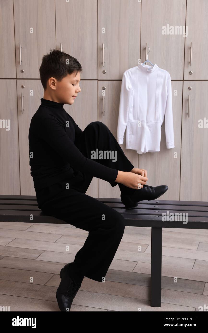Little boy putting on shoes in locker room Stock Photo Alamy
