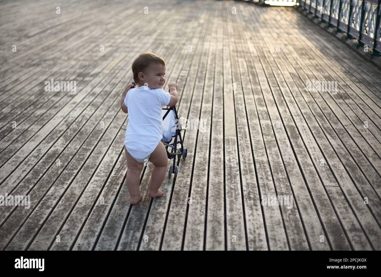 baby pushing pram on a pier Stock Photo Alamy