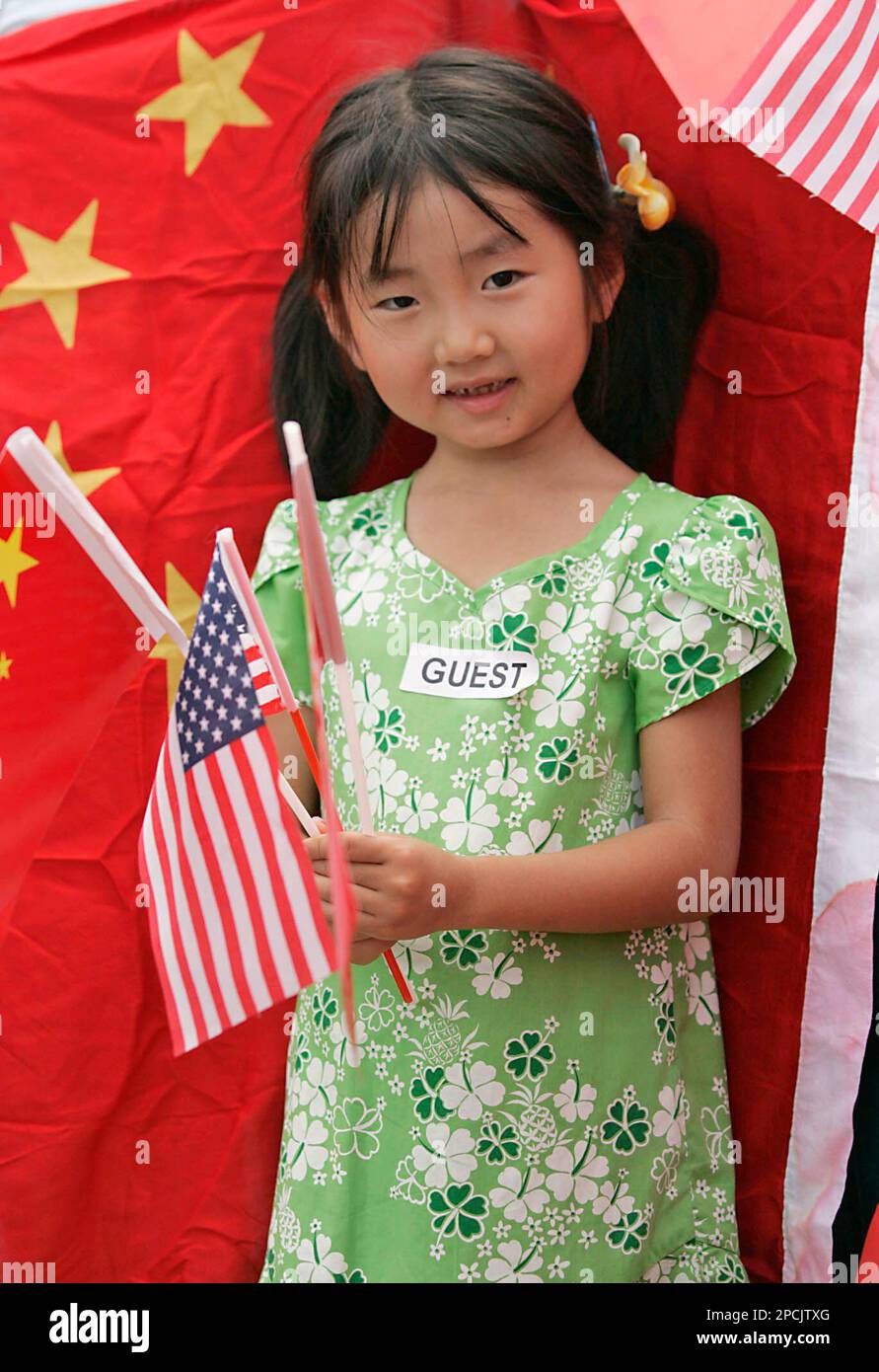 Six year old Li Hui Yan waves both an American and Chinese flag welcoming a visiting Chinese Navy ship docking at Naval Station Pearl Harbor, Wednesday, Sept. 6, 2006, in Pearl Harbor, Hawaii. The Qingdao, a Luhu-class guided missile cruiser, and the Hongzehu, a refueling ship, arrived for four days of exercises, personnel exchanges, and touring. (AP Photo/Marco Garcia) Stock Photo