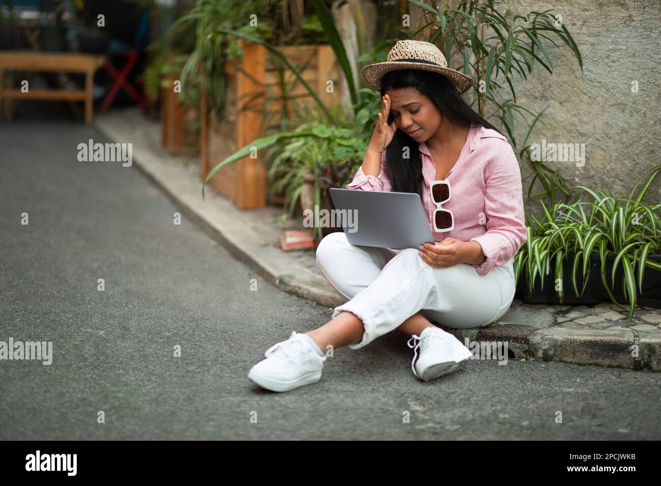 Sad millennial african american lady tourist in casual and hat sits on ...