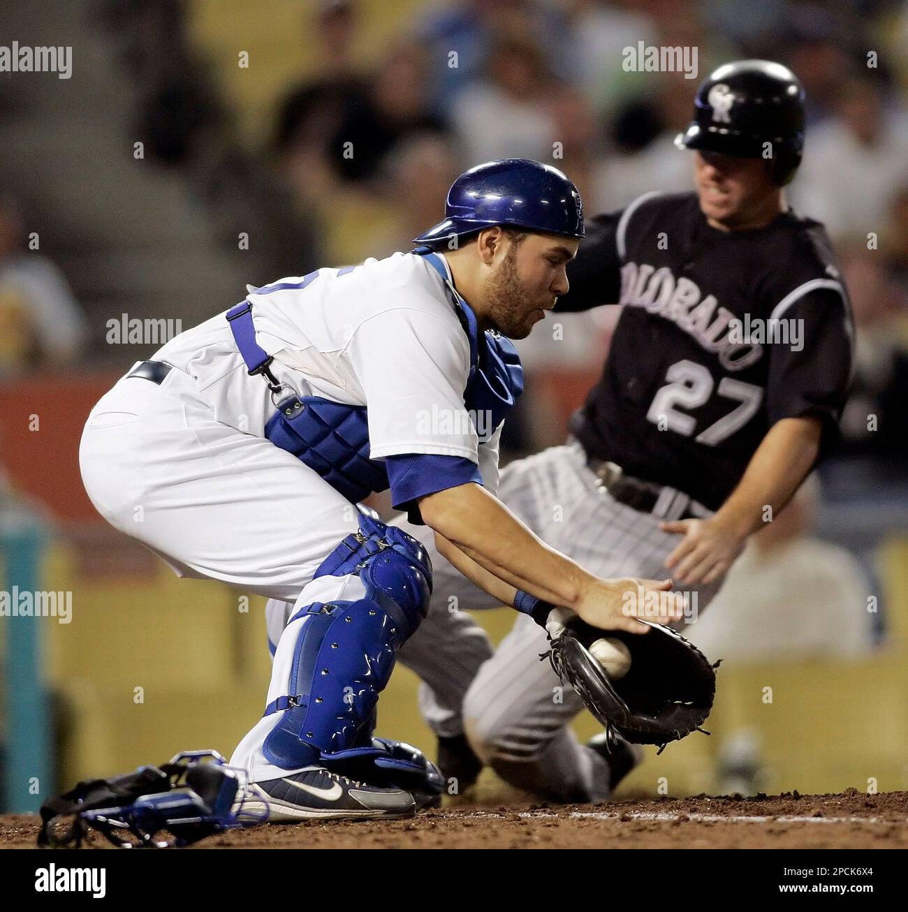 Colorado Rockies' Garrett Atkins, right, slides safely past Los Angeles  Dodgers catcher Russell Martin, scoring on a single by Brad Hawpe in the  sixth inning of a baseball game in Los Angeles