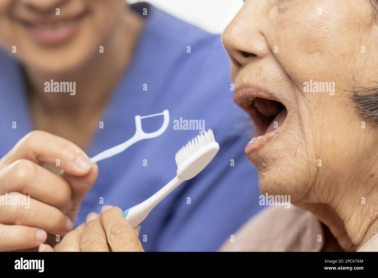 Dental and oral health , Caregiver take care asian elderly woman while brush teeth. Stock Photo