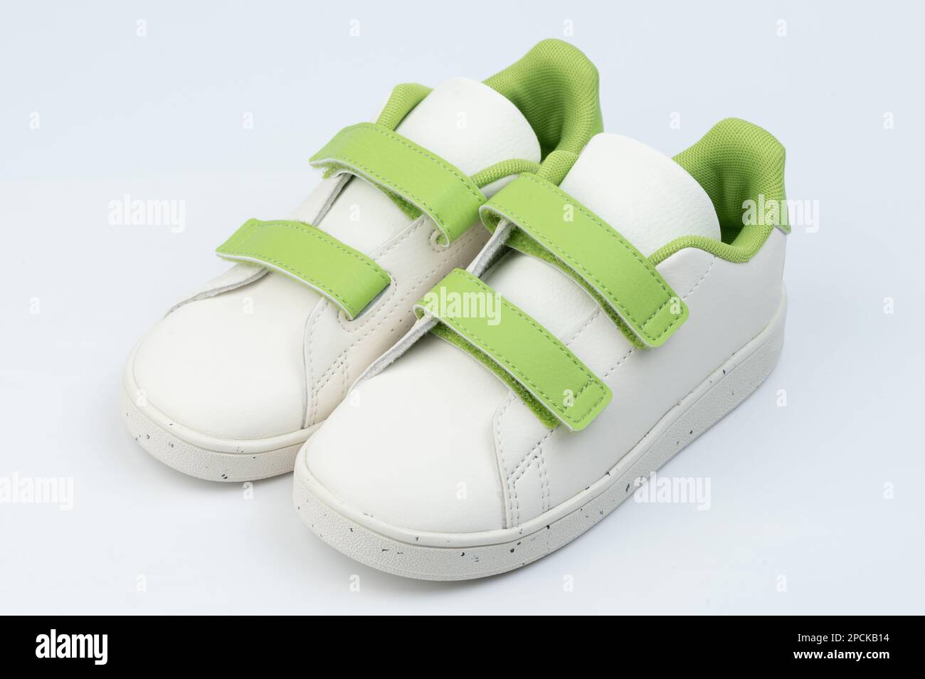 White with green velcro pair shoes isolated on studio background Stock Photo