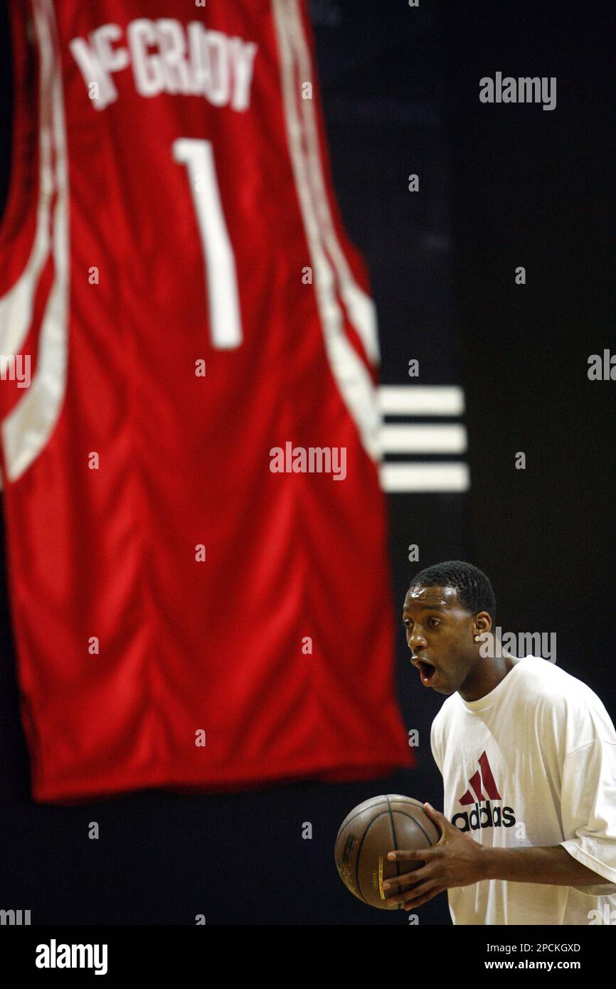 Houston Rockets ' Tracy McGrady reacts in front of a huge jersey