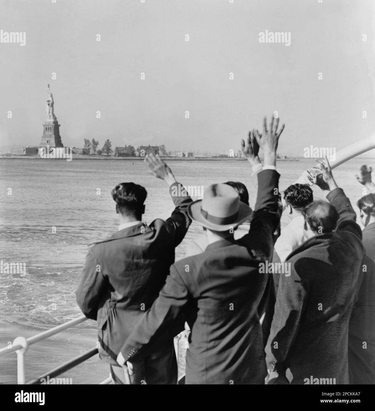1952,  New York , USA : Part of a group of 171 aliens illegally in the country wave goodby to the Statue of Liberty from the Coast Guard cutter that took them from Ellis Island to the Home Lines ship Argentina in Hoboken for deportation . Photo by Al Ravenna of New York World-Telegram and the Sun Newspaper.  The french architect and sculptor artist  FREDERIC AUGUSTE BARTHOLDI (Colmar, Alsace 1834 - 1904 ) was the author of Statue of Liberty in the New York Harbor on Bedloe's Island . - ARCHITETTO - ARCHITETTURA - SCULTORE - SCULTURA - SCULPTURE - ARTS - ARTE  -  STATUA DELLA Libertà  - FOTO ST Stock Photo