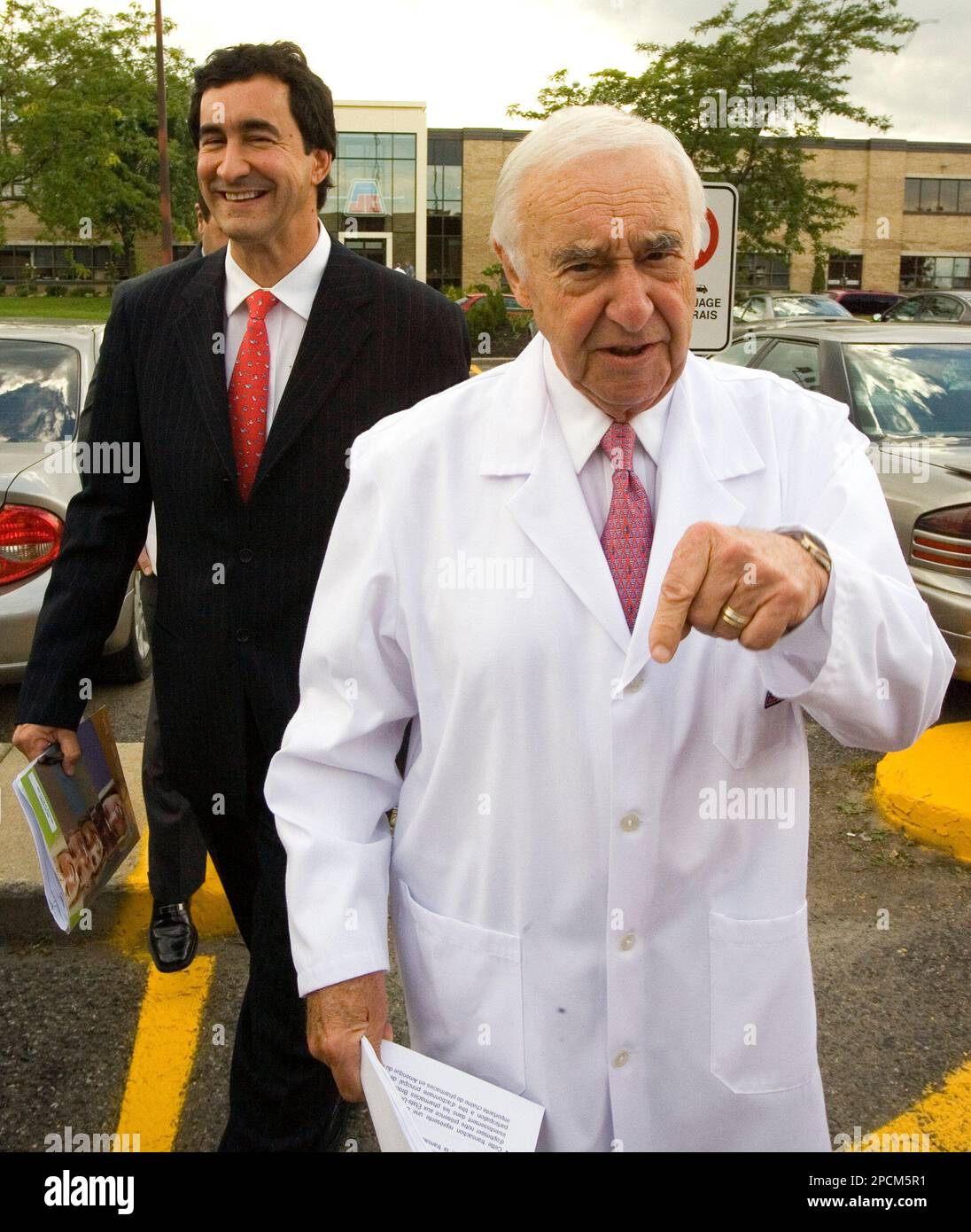 Jean Coutu, chairman and CEO of Jean Coutu Group, walks to a news  conference accompanied by his son Francois, president of Canadian  operations Thursday, Aug. 24, 2006 in Longueuil, Quebec,Canada. The pharmacy