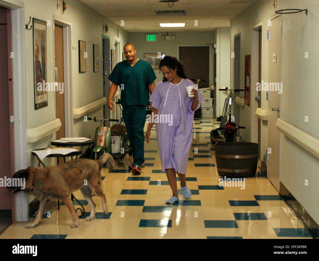 Actor Donald Faison, left, and Judy Reyes follow Reyes' dog Chulo down