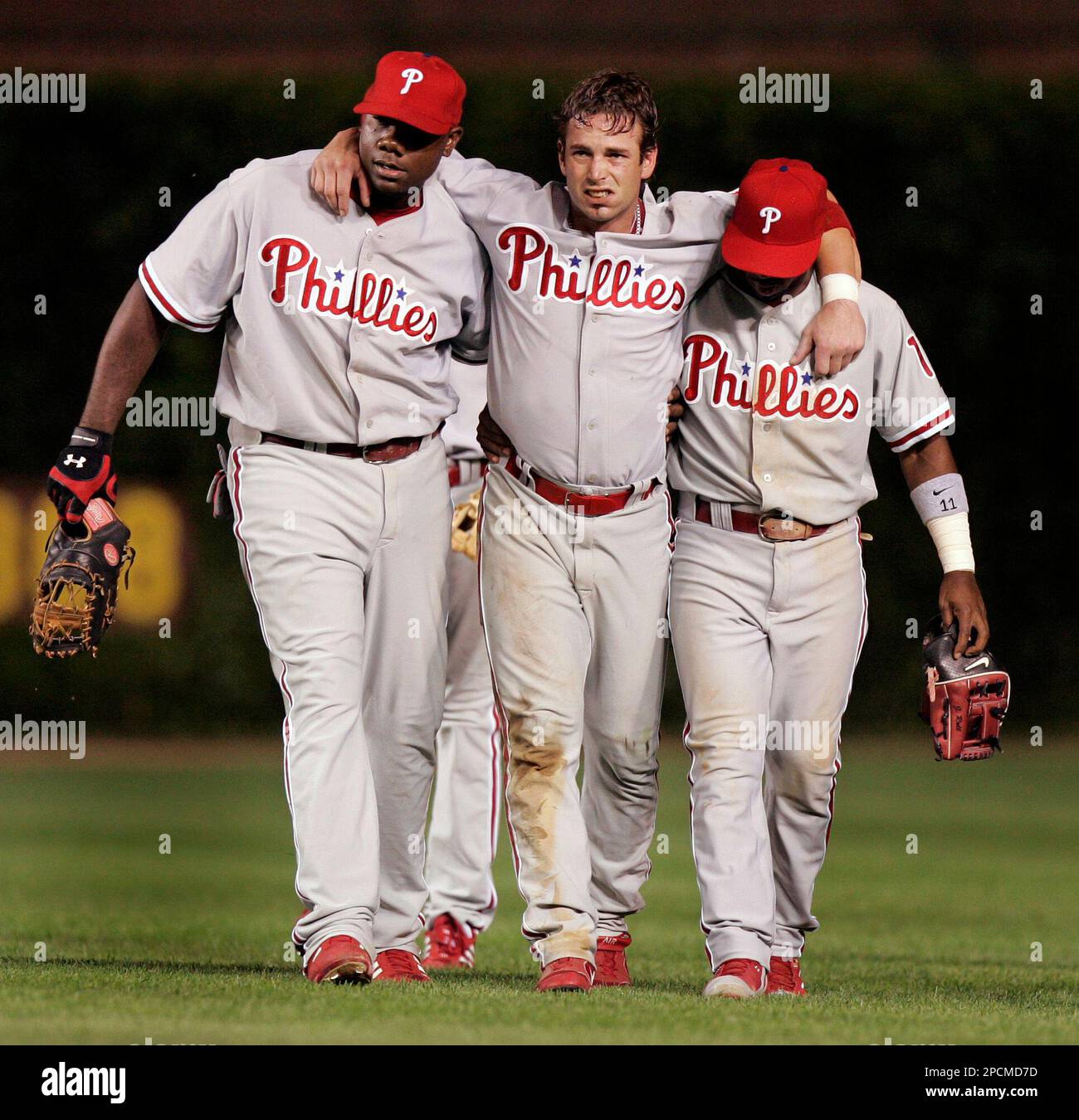 Philadelphia Phillies center fielder Aaron Rowand, center, is helped off  the field by teammates Ryan Howard, left, and Jimmy Rollins, right, after  colliding with second baseman Chase Utley while chasing a fly